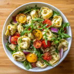 Fresh tortellini salad with tomatoes, arugula, basil, and Italian dressing