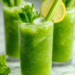 Serving glass of chilled celery cleanse juice with ice, a celery leaf garnish, and lemon slice.