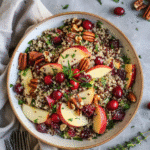 Cozy Cranberry Apple Quinoa Winter Salad with apples, cranberries, and nuts served in a bowl