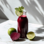 beet lime ginger cleanse juice served over ice with lime garnish and mint