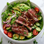 Best Steak Salad Recipe: How to Make a Delicious and Healthy Meal at Home 6 steak salad with medium-rare sliced steak, mixed greens, avocado, tomatoes, and vinaigrette