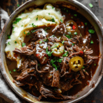 tender Mississippi pot roast with gravy and pepperoncini served over mashed potatoes