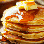 fluffy homemade pancakes stacked with maple syrup and butter