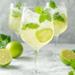 Alcohol-free Hugo spritz mocktail with elderflower syrup, sparkling water, mint, lime, and ice.