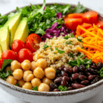 High fiber salad with quinoa, chickpeas, black beans, kale, avocado, crunchy vegetables, and lemon garlic dressing.