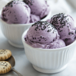 Black Sesame Ice Cream: How to Make the Best Dairy-Free Dessert 6 Served black sesame ice cream scoops with toasted sesame seeds in small dessert bowls.